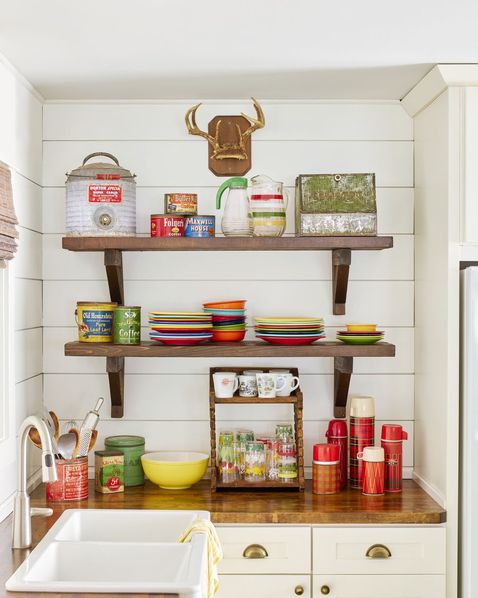 kitchen shelves filled with fiestaware and plaid thermoses