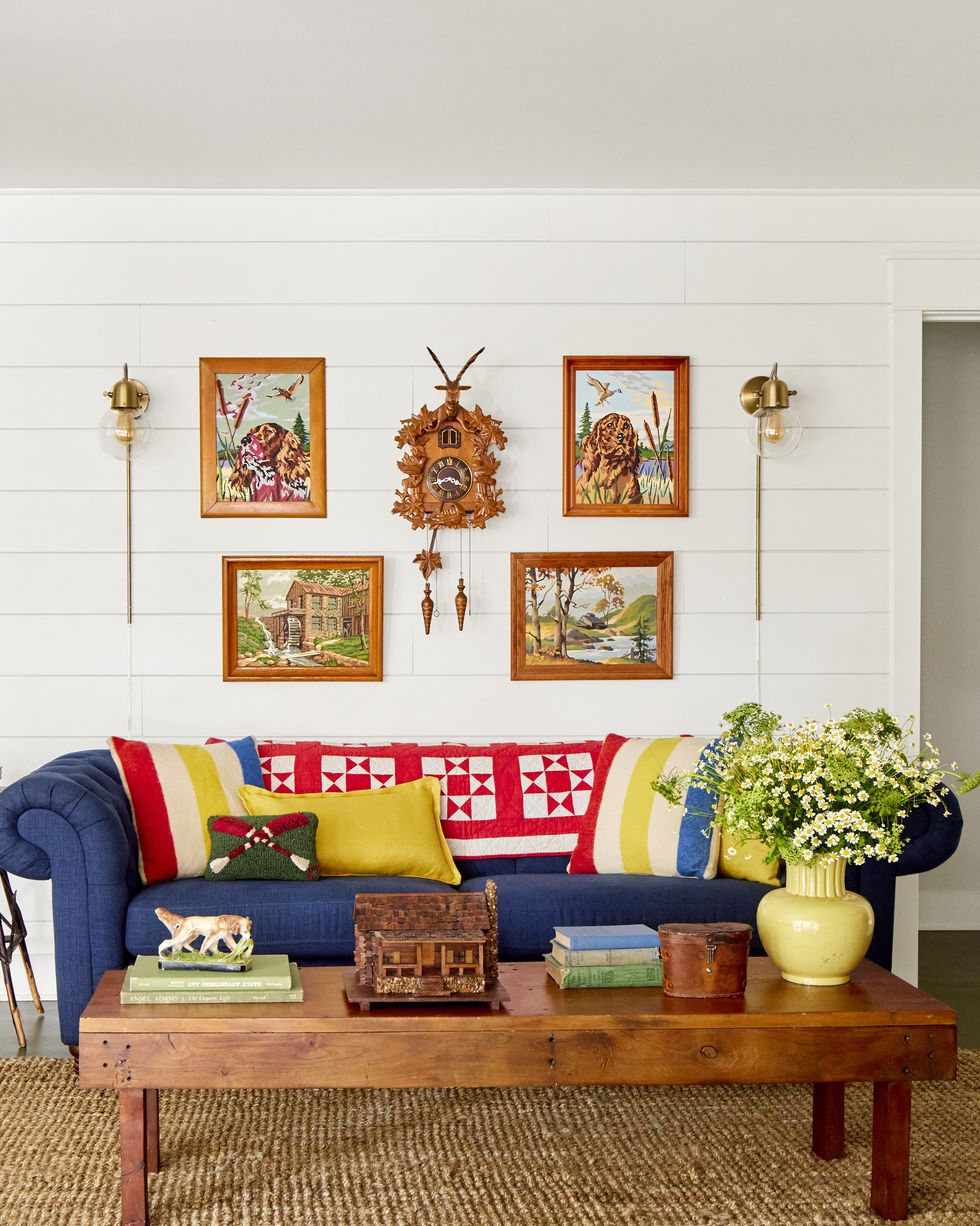 a living room with a navy sofa and a red and white quilt
