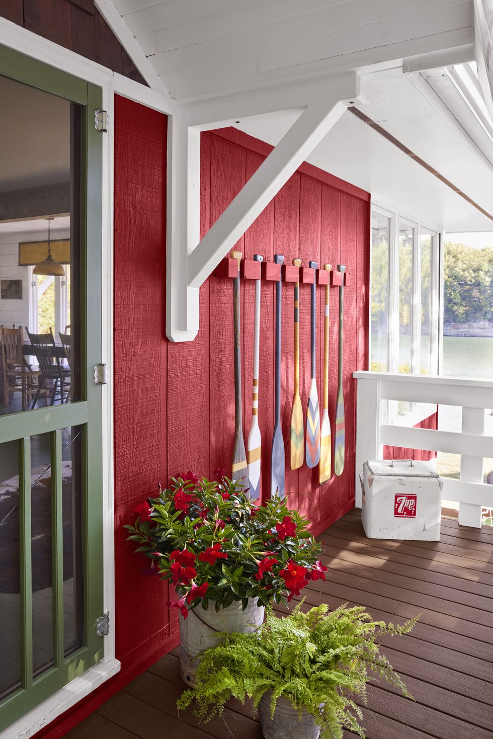 red lake cabin front porch with painted paddles hanging on the wall
