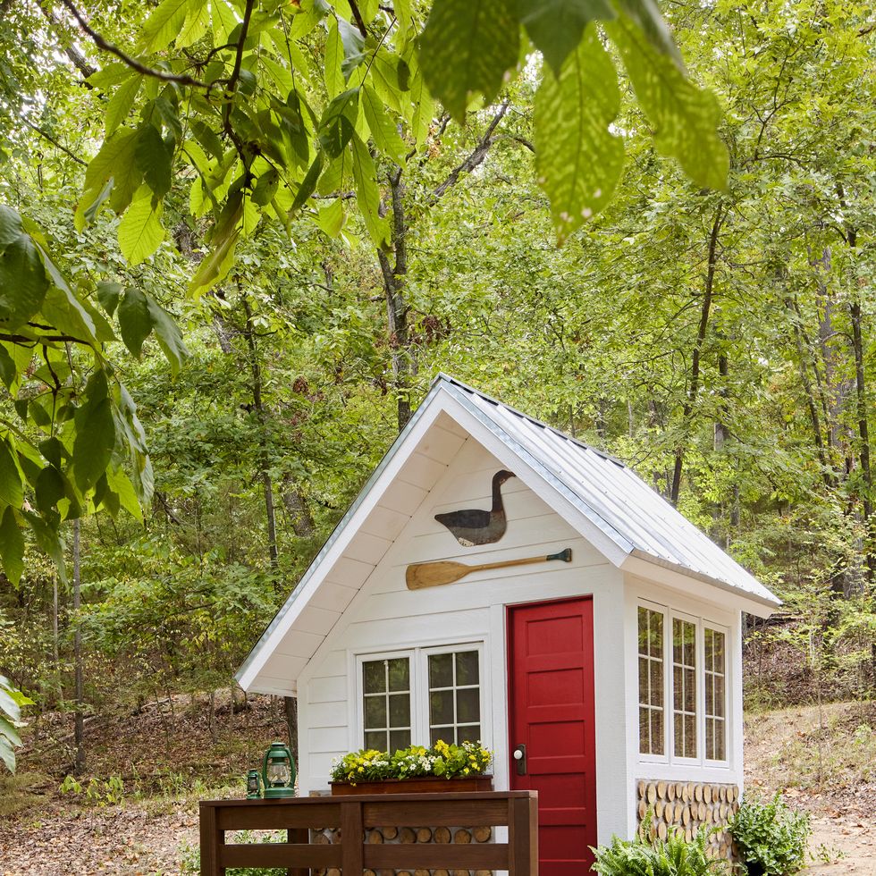 white lake cabin playhouse with red door