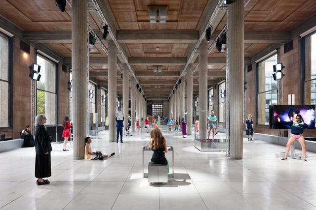 an expansive gallery space featuring several figures positioned throughout