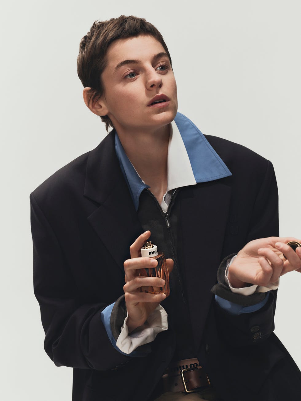 a person holding a perfume bottle