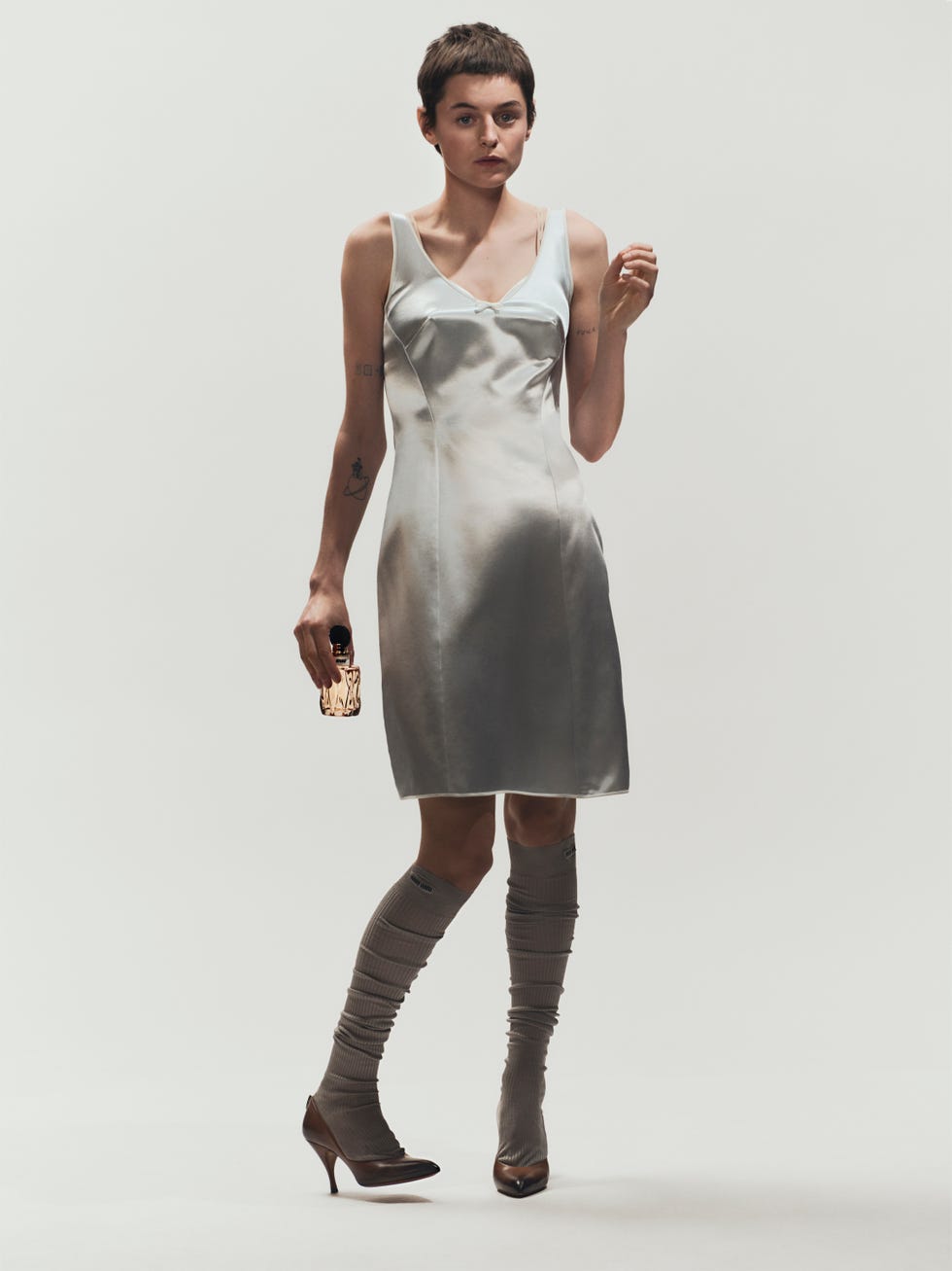 a stylish individual wearing a light dress and kneehigh socks