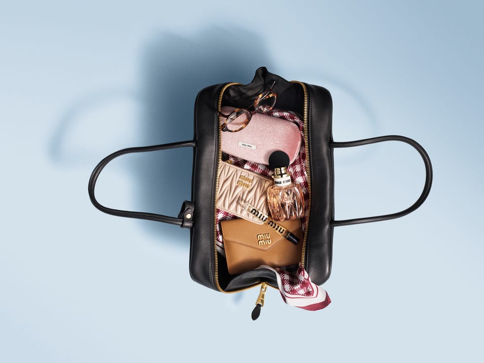 contents of a black handbag including accessories and cosmetics