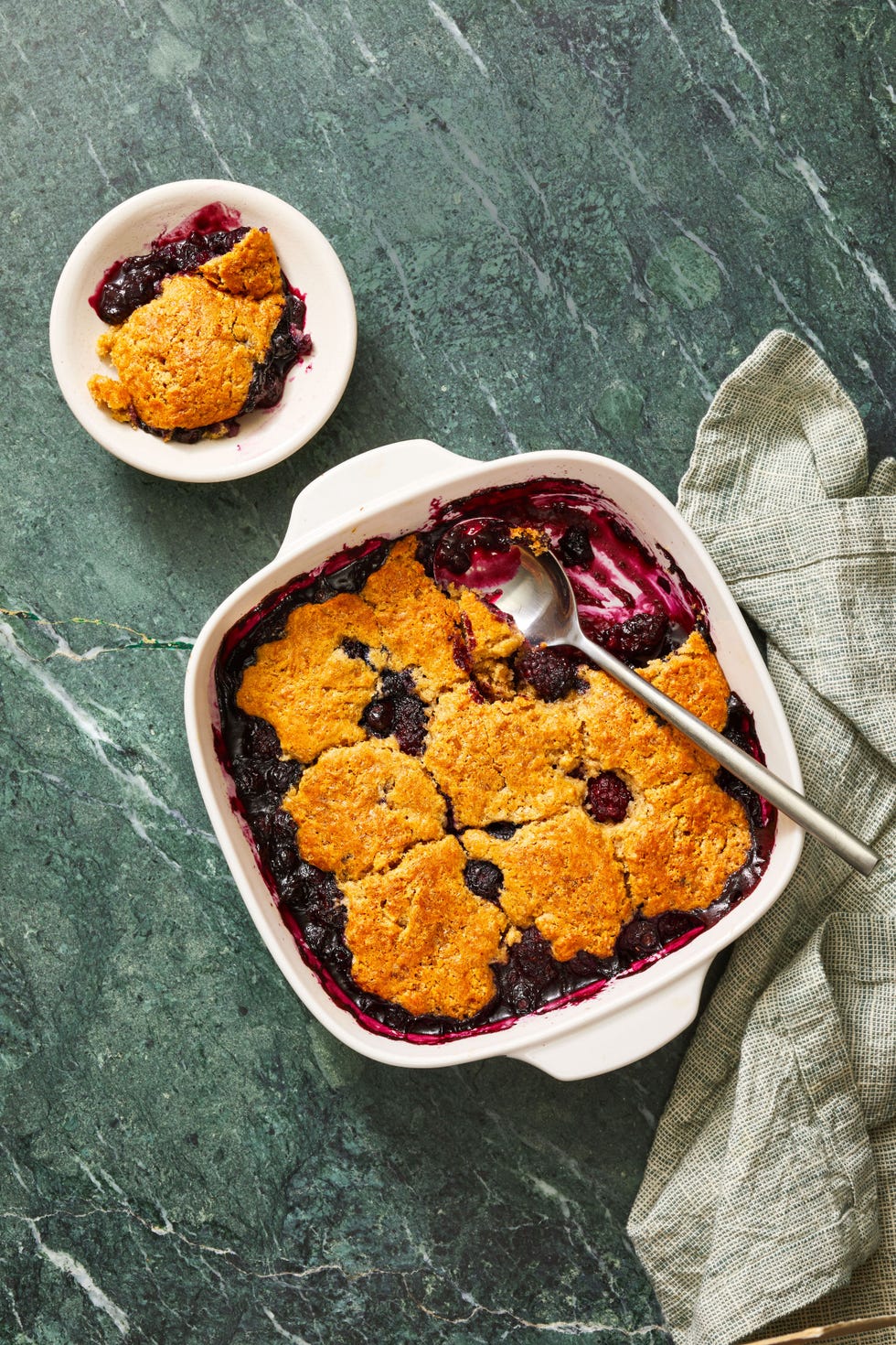 mixed berry cobbler in a white casserole pan