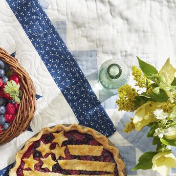 mixed berry flag pie on a quilt with a basket of berries