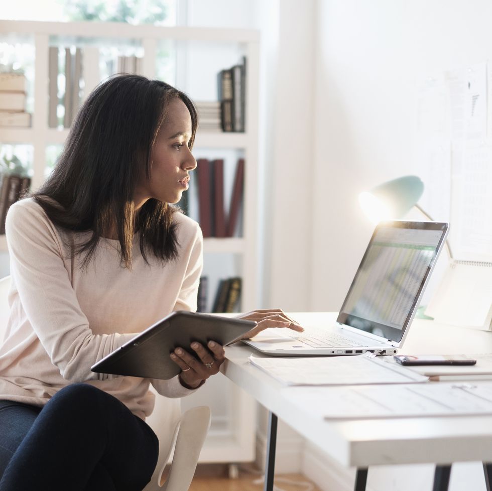 mixed race businesswoman using laptop