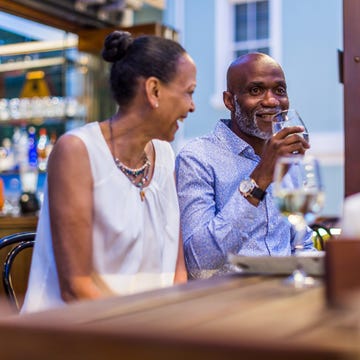 mixed race couple drinking wine together in a bar at night