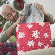mixed race grandfather and grandson opening christmas gifts