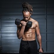mixed race man lifting weights in gymnasium