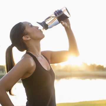 vrouw drinkt na het sporten uit een waterfles met filter