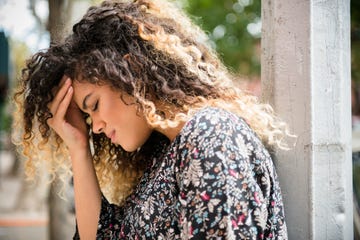 mixed race woman rubbing forehead