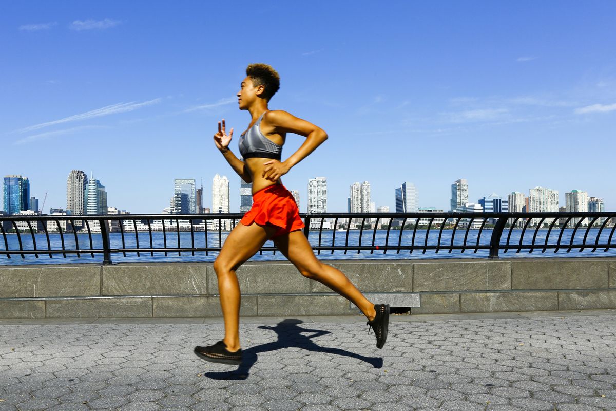 mixed race woman running at waterfront