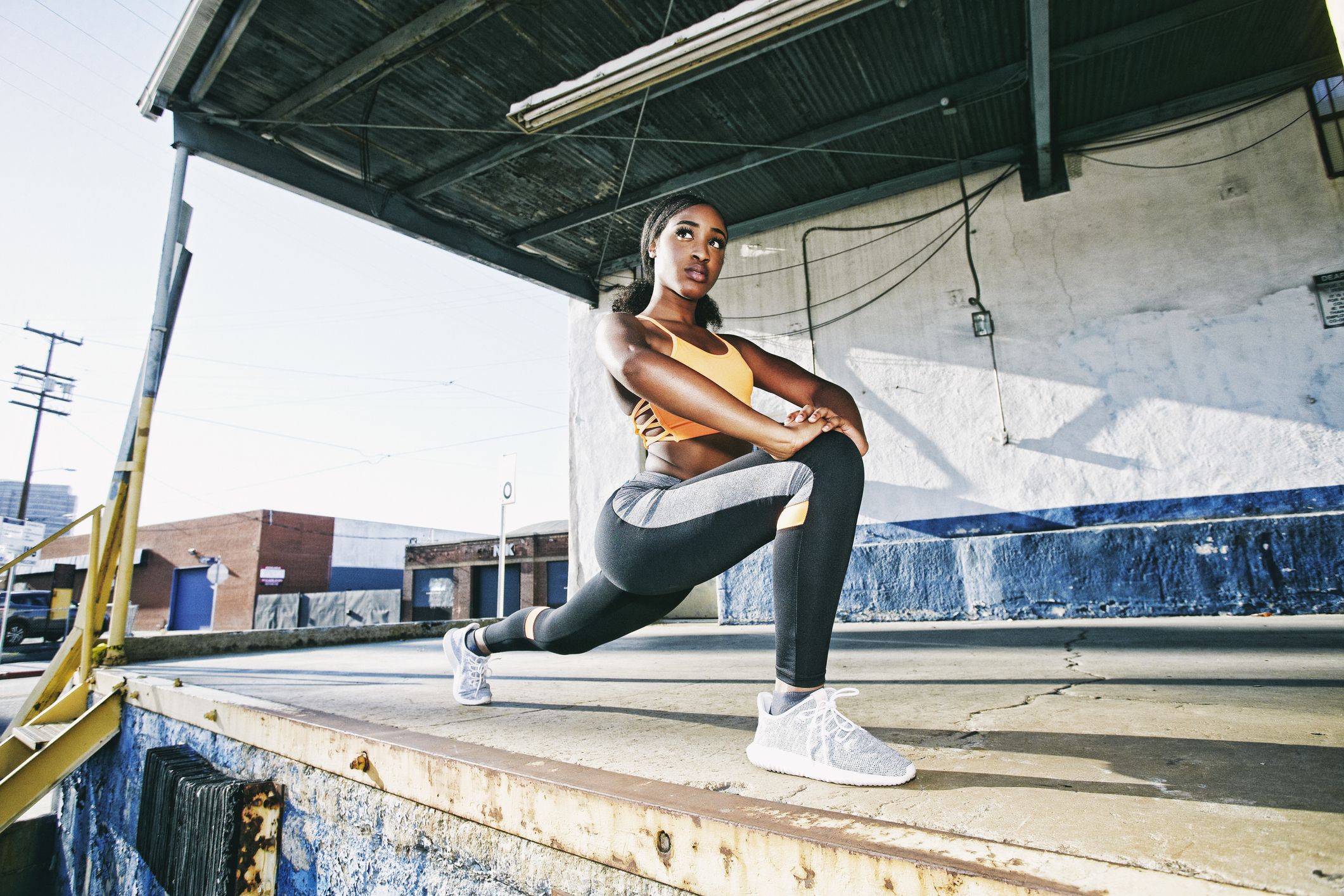 mixed race woman stretching legs on loading dock royalty free image