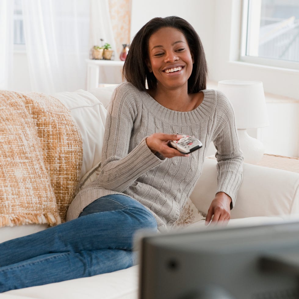 mixed race woman watching television in living room