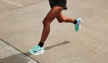 a person's legs running in green running shoes