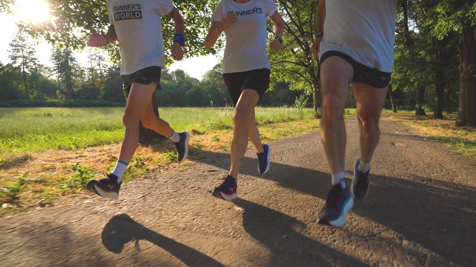 group of three runners in motion on a gravel path during daytime