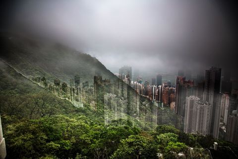 Uitzicht vanaf de beboste Victoria Peak over wolkenkrabbers in het dichtbevolkte Hongkong Fotograaf Nicolas Ruel brengt de stad en het omringende groen samen in n afbeelding