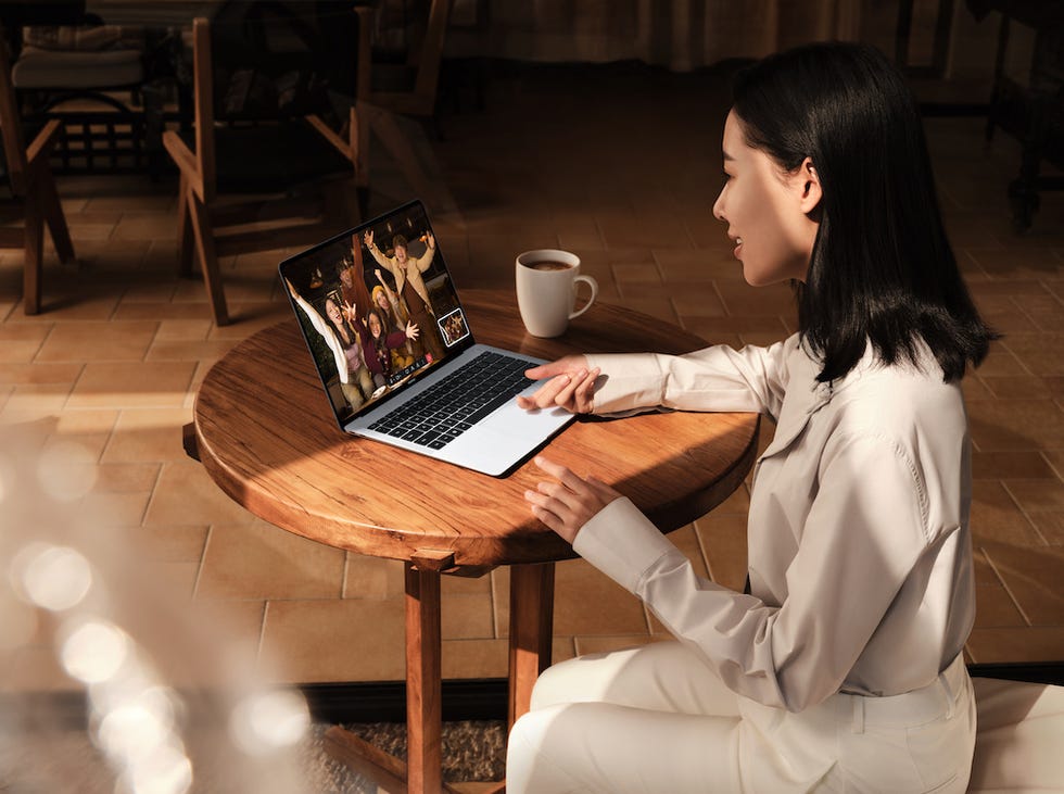 une personne assise à une table utilisant un ordinateur portable