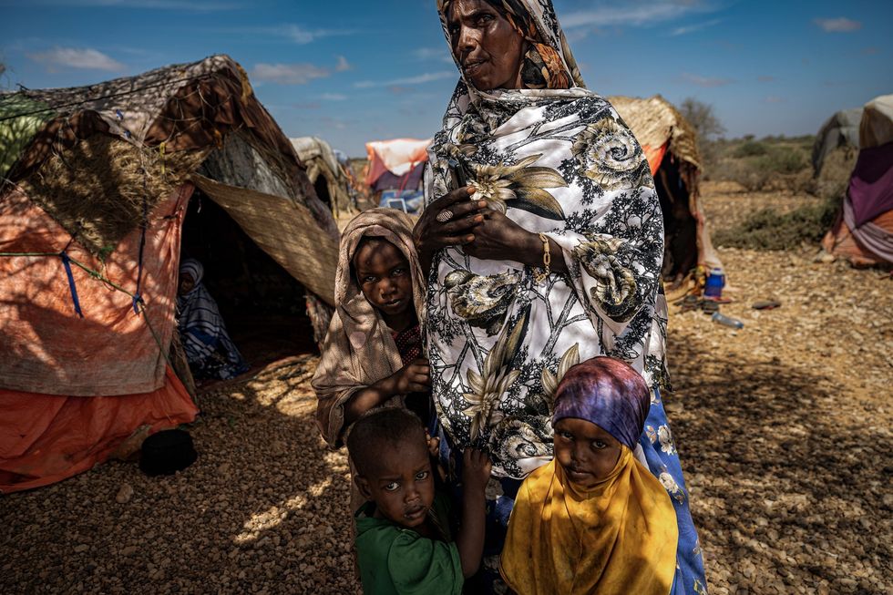 In een opvangkamp bij de Somalische stad Baidoa staat Sadio Abdi Rahman Ahmed 50 met drie van haar zes kinderen voor haar hut Van links naar rechts Faiso 8 Abdi Haffid 3 en Ahalan 5