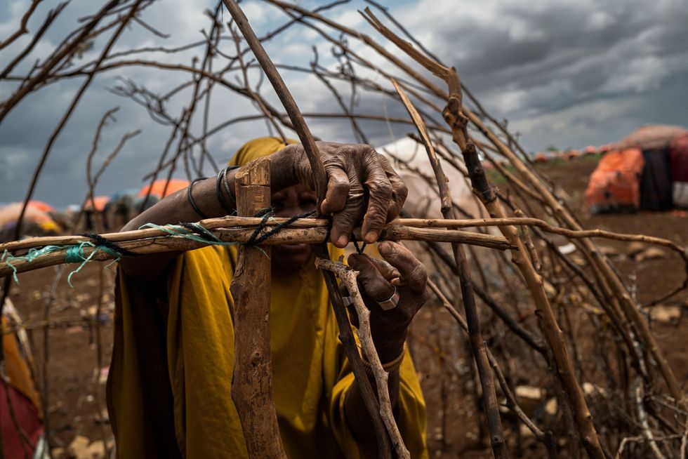 In het opvangkamp van Bolo Isaack Madow bij de Somalische stad Baidoa bouwt een ontheemde Somalische vrouw een nieuwe hut Meer dan n miljoen mensen zijn door de aanhoudende droogte in het gebied uit hun dorpen verdreven
