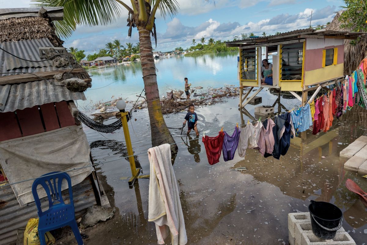 Gezinnen in Kiribati vooral zij die nieuw zijn in de eilandnatie zijn vaak gedwongen te leven in marginale gebieden waar de overstromingen door hoogwater toenemen