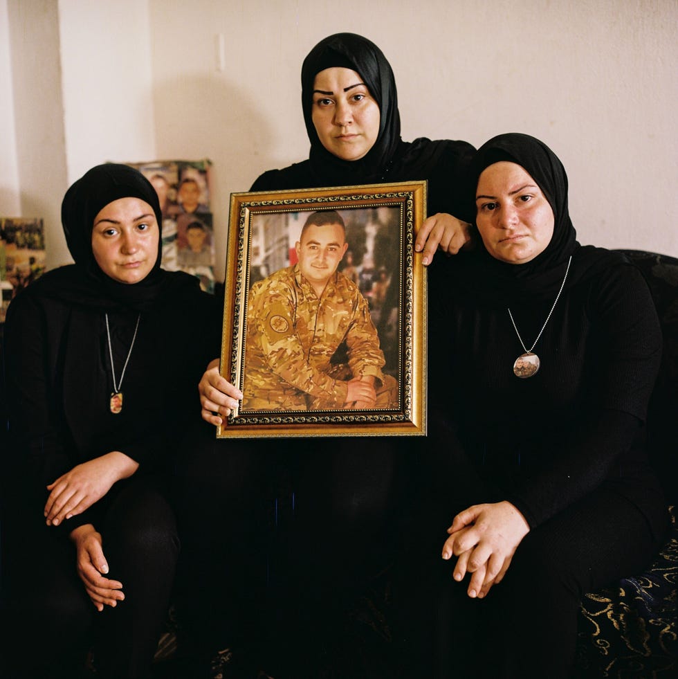 Ruim een jaar na de enorme explosie in de haven van Beiroet rouwen Libanese families nog steeds om het verlies van hun dierbaren De 25jarige Hamze Eskandar was als soldaat in de haven gestationeerd toen enkele duizenden kilos aan opgeslagen ammoniumnitraat op 4 augustus 2020 explodeerden Bij de ontploffing kwamen hij en ruim 200 anderen om het leven Zijn drie zussen tonen hier zijn portret en dragen een medaillon met een foto van hem om hun nek