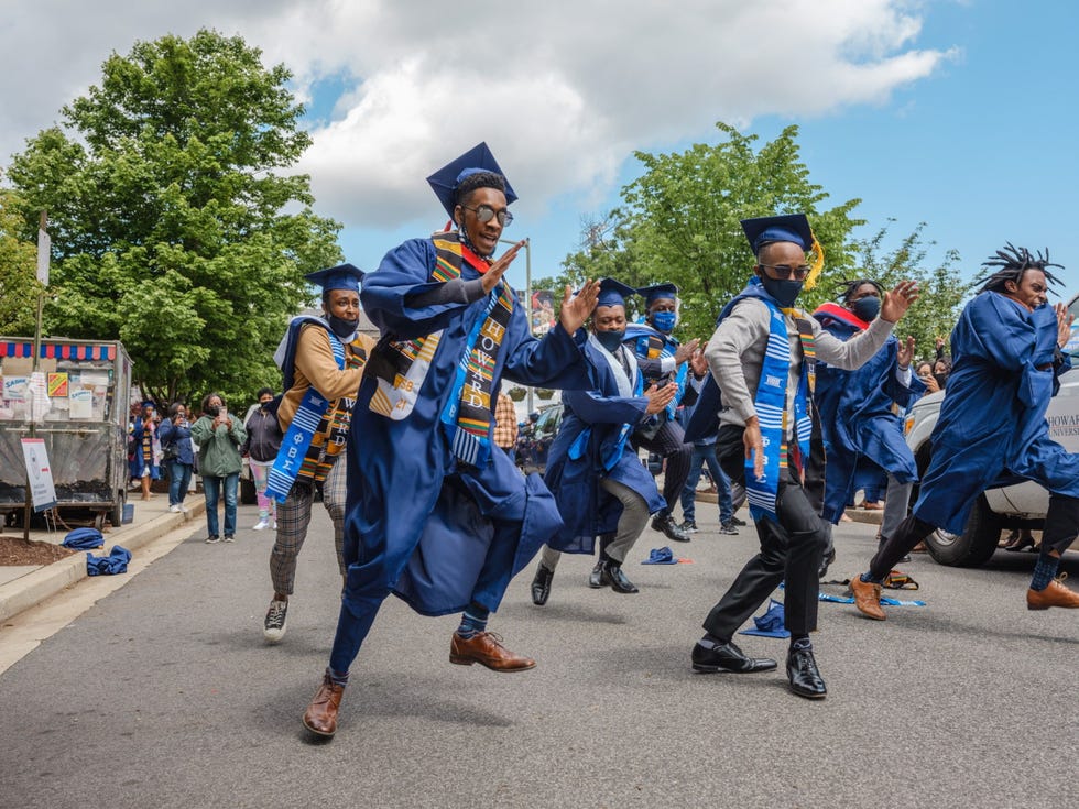 MM9490_210509_13863 (1).JPG Leden van studentenvereniging Phi Beta Sigma van de Howard University in Washington DC lopen in een feestelijke gechoreografeerde optocht over Sixth Street NW en volgen daarmee een oude traditie ter ere van hun afstuderen Het is een overgangsrite aldus Travis Xavier Brown uiterst rechts die theaterwetenschappen deed Door de pandemie moesten de lessen op de universiteit online worden gegeven Toen het aantal coronagevallen terugliep besloot de school een gezamenlijke feestdag te houden waar alle afgestudeerden uit 2020 en 2021 bij aanwezig mochten zijn
