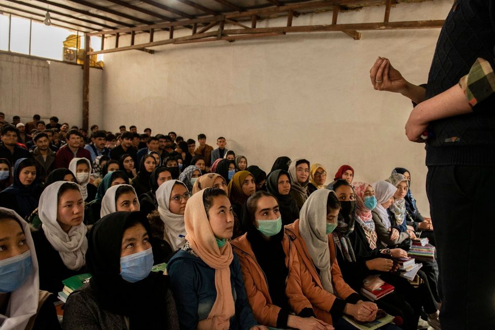Op 20 maart 2021 zitten mannelijke en vrouwelijke studenten in een bomvolle collegezaal van deMawoudAcademy in Kaboel Ruim twee jaar eerder stierven ten minste veertig studenten bij een zelfmoordaanslag tijdens een wiskundeles De meeste slachtoffers behoorden tot deHazara een etnische minderheid in Afghanistan
