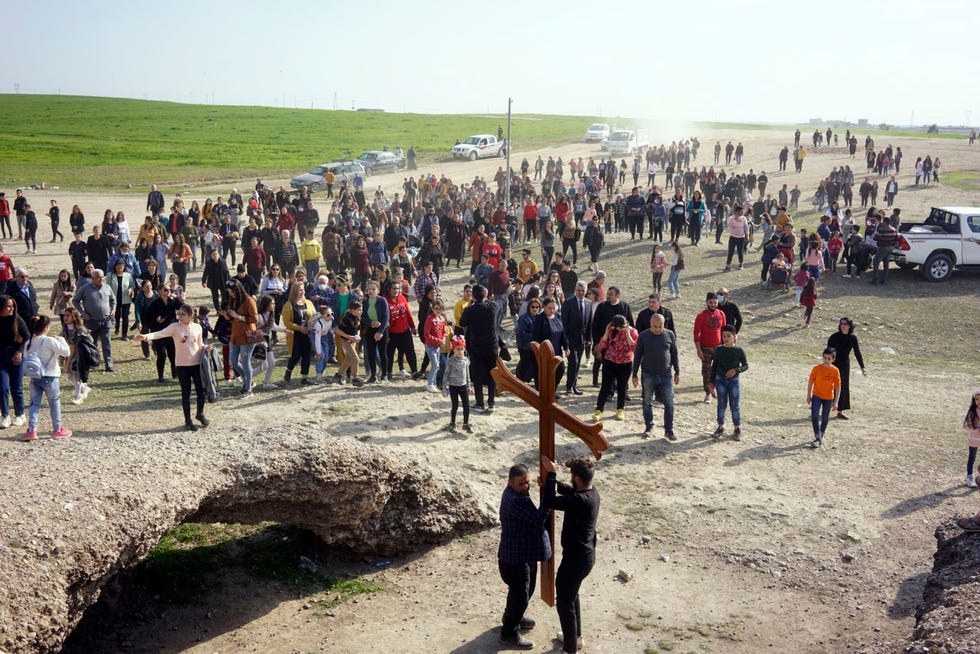 Iraakse christenen komen aan de rand van de stad Qaraqosh bijeen om te bidden ter voorbereiding van de komst van de paus Hij riep op tot vergeving van de ISextremisten die hun kerken en een groot deel van de van oudsher christelijke stad verwoestten