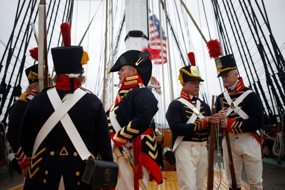 Van links naar rechts reenactors Henry Rodriguez Suzanne Rodriguez Stan Kumor Brian Cafarella en Robert Sheridan van de 1812 Marine Guard bereiden zich aan boord van de USS Constitution voor op een voorstelling De groep vrijwilligers maakt gebruik van authentieke uniformen en wapens om het publiek voor te lichten over het dagelijks leven van een eenheid Amerikaanse mariniers die gedurende de Oorlog van 1812 op het schip dienst deed