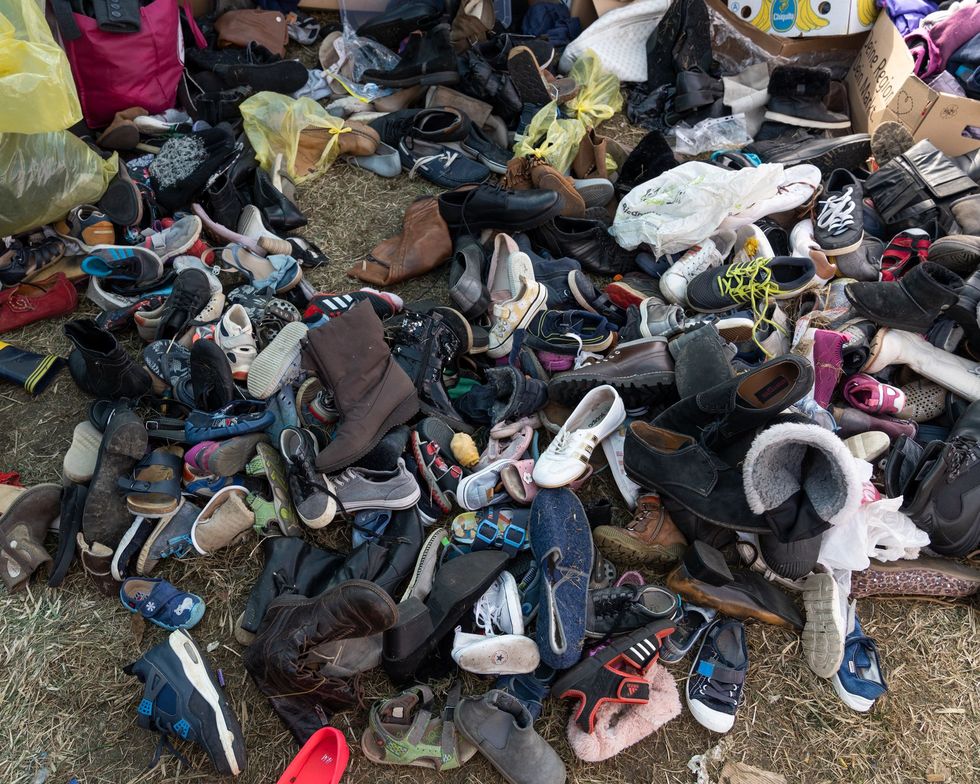 Een stapel schoenen die door vrijwilligers zijn verzameld staat klaar om te worden uitgedeeld aan vluchtelingen uit Oekrane die Polen in de buurt van Przemyl zijn binnenkomen