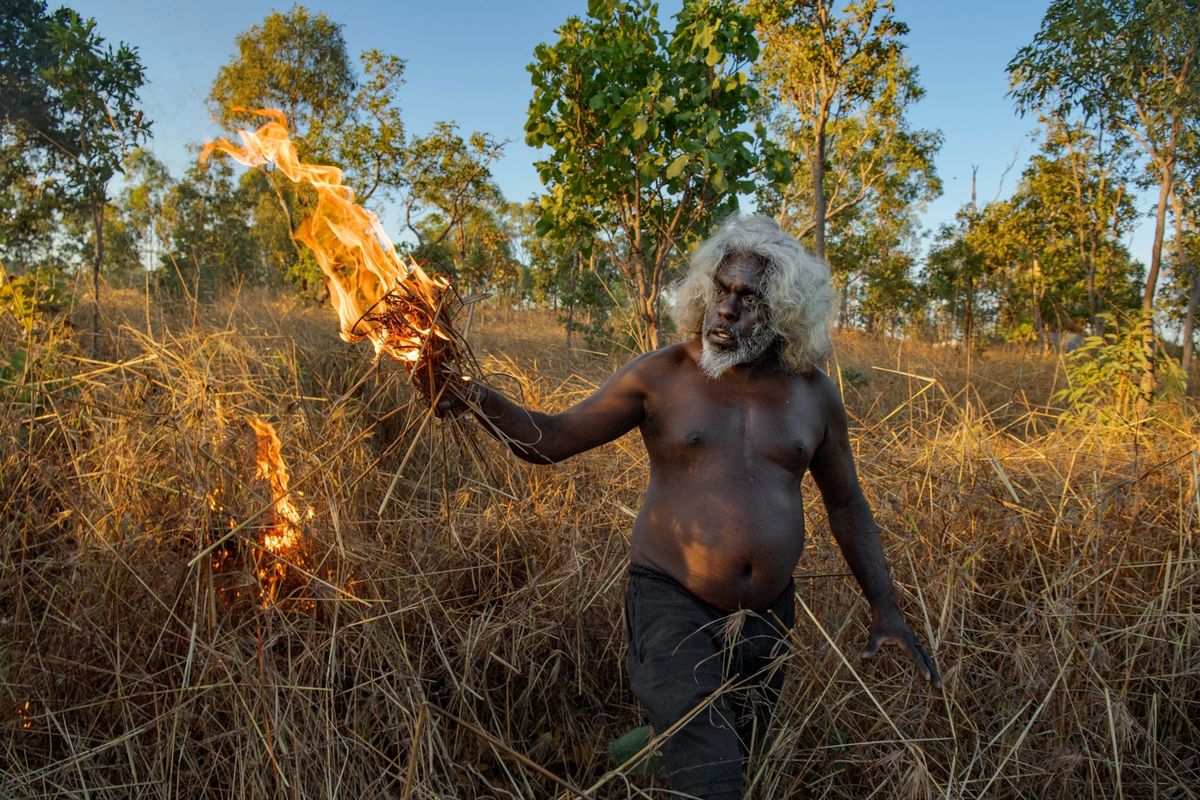 Nabij zijn dorp Mamadawerre een buitenpost aan de noordgrens van de Warddeken Indigenous Protected Area ontsteekt Conrad Maralngurra een traag brandende beheerbrand s Zomers veroorzaken blikseminslagen geregeld bosbranden op de tropische savanne