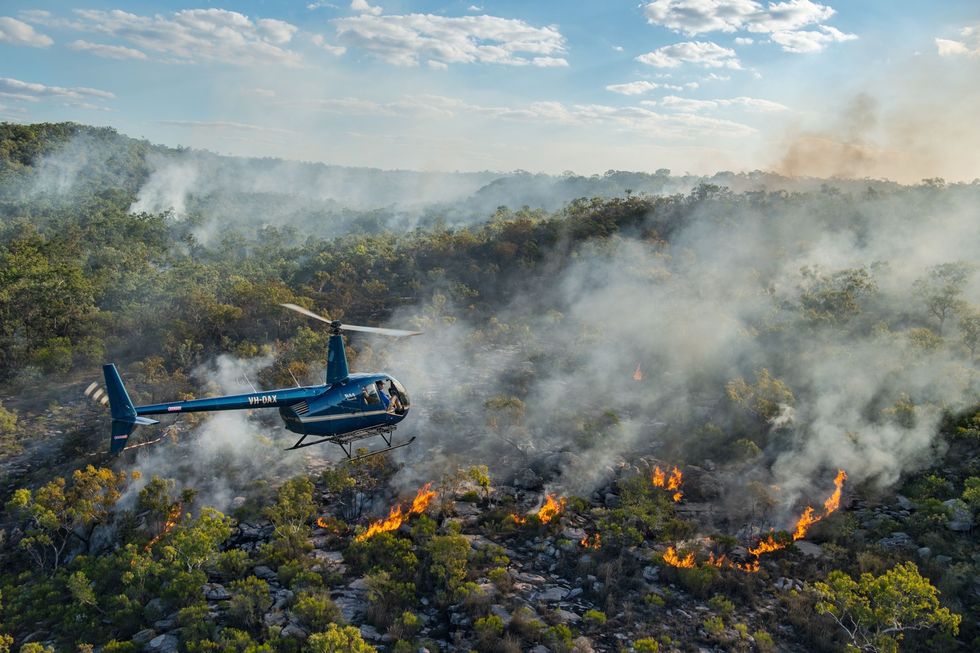 Vanuit een helikopter die wordt bestuurd door Terrah Guymala opzichter van het Warddekenreservaat worden brandpellets gegooid die door een vertraagde chemische reactie op de grond ontvlammen en zo een beheerbrand starten