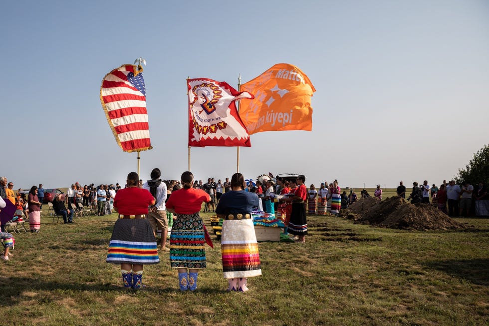 Onder het toeziend oog van een erewacht krijgen op 17 juli de stoffelijke resten van zes inheems Amerikaanse kinderen die werden opgegraven bij een voormalige kostschool in Pennsylvania een laatste rustplaats in het Rosebud Sioux Reservation in South Dakota De stoffelijke overschotten van drie andere kinderen werden aan familieleden teruggegeven voor een privbegrafenis