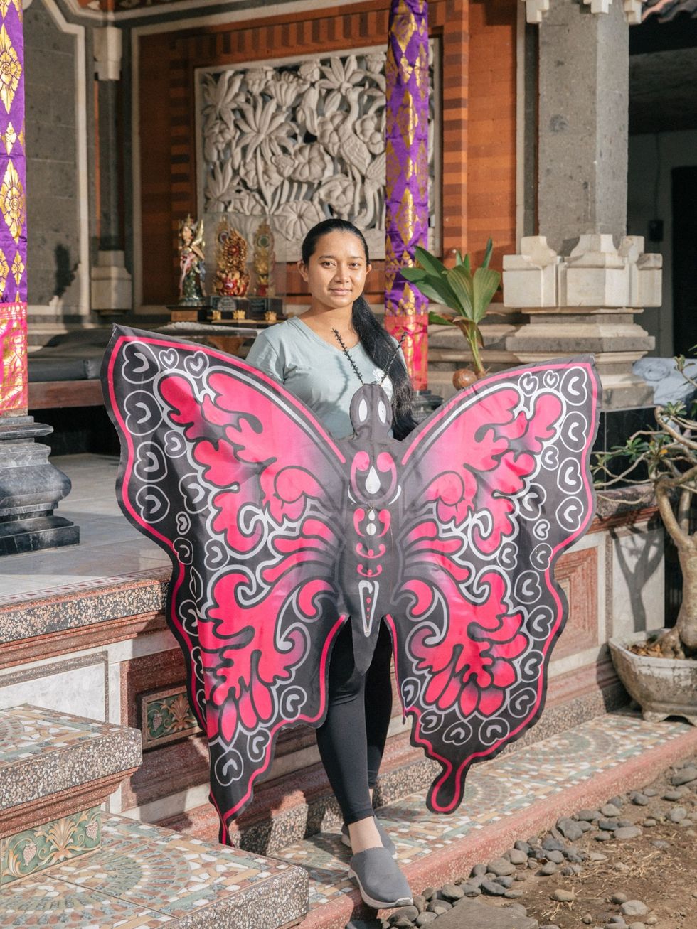 Nyoman Padmi Triyanti poseert met een vlieger voor een portret in Renon Ze is een van de leden van Srikandi het enige vliegerteam in Bali dat alleen uit vrouwen bestaat