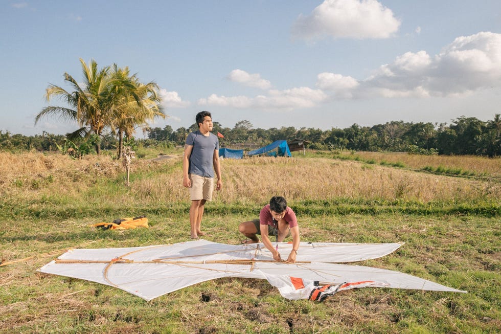 Made Semara Putra links en Putu Agus Adi Setiawan zijn bezig een bebean te maken in een rijsveld bij het dorp Tunjuk Bebean de traditionele vlieger in de vorm van een vis is populair in Bali en wordt gezien als de vlieger die het makkelijkst te besturen is