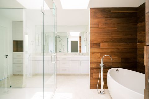 modern master bathroom with wood accent wall and large tub