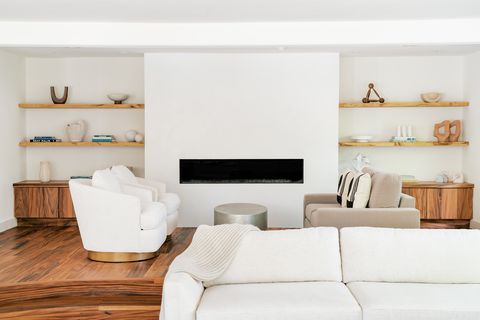 behind the couch is a seating area around a fireplace
