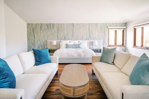 master bedroom after with light walls and wallpaper and a sitting area