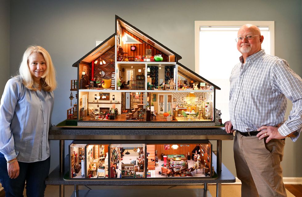 man and woman with dollhouse
