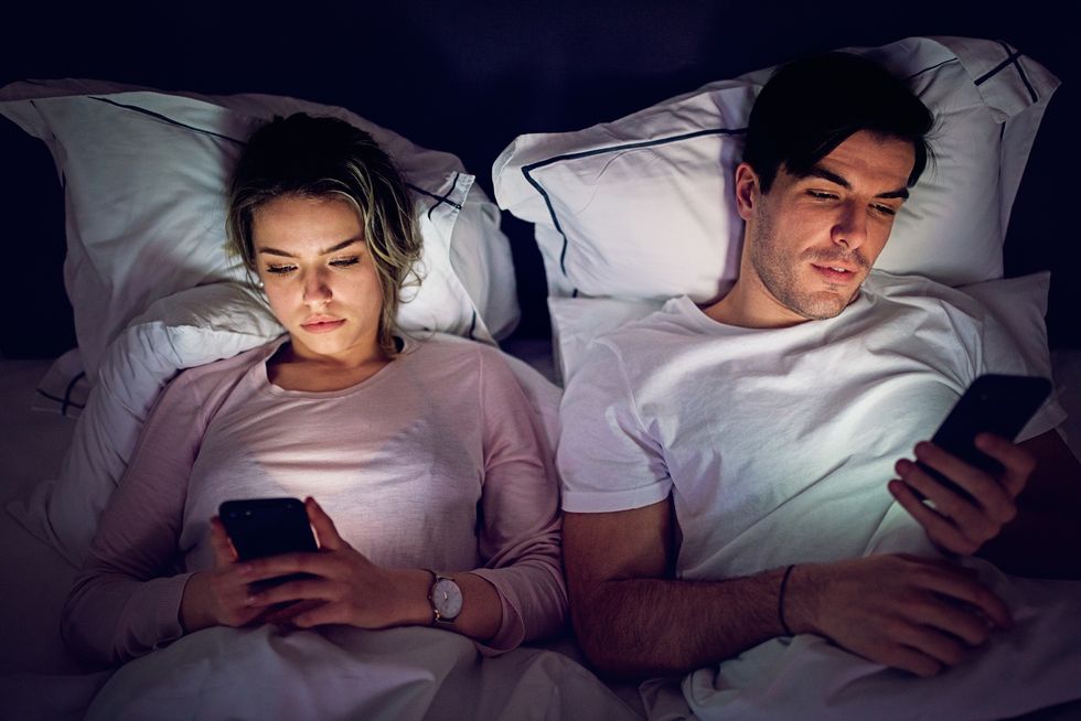 mobile phone addiction   couple is texting and browsing in the bed