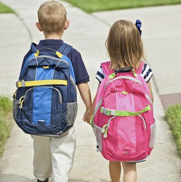 niños con mochila yendo al colegio