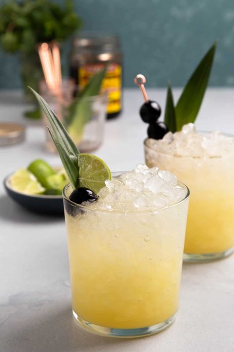 pineapple ginger beer mocktail in short glasses with crushed ice cherries and limes
