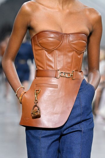 a model wearing a strapless leather bustier top on the fendi runway in a roundup of the best strapless bras for small chests 2023