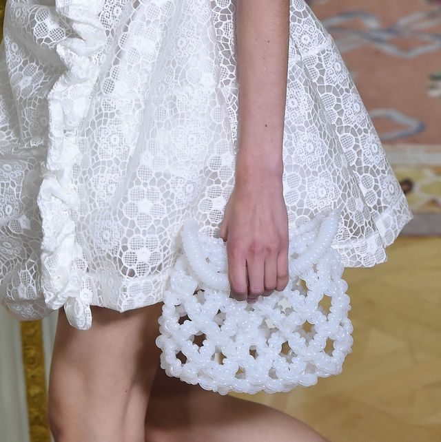 a model carries a pearl clutch in a guide to the best bridal clutches 2023