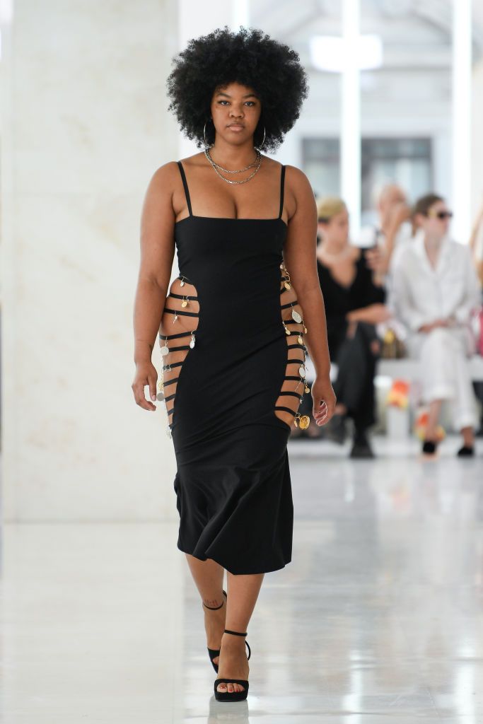 a model walks at the karoline vitto show wearing a side cutout dress adorned with charms