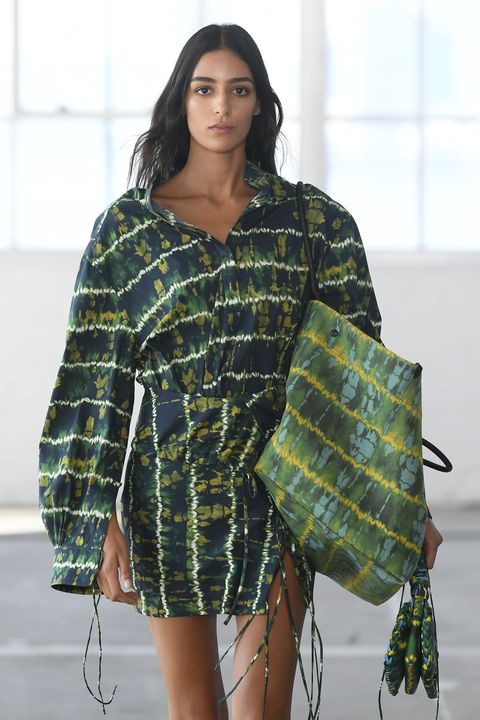 a model carries a printed altuzarra tote bag in a roundup of summer 2023 bag trends