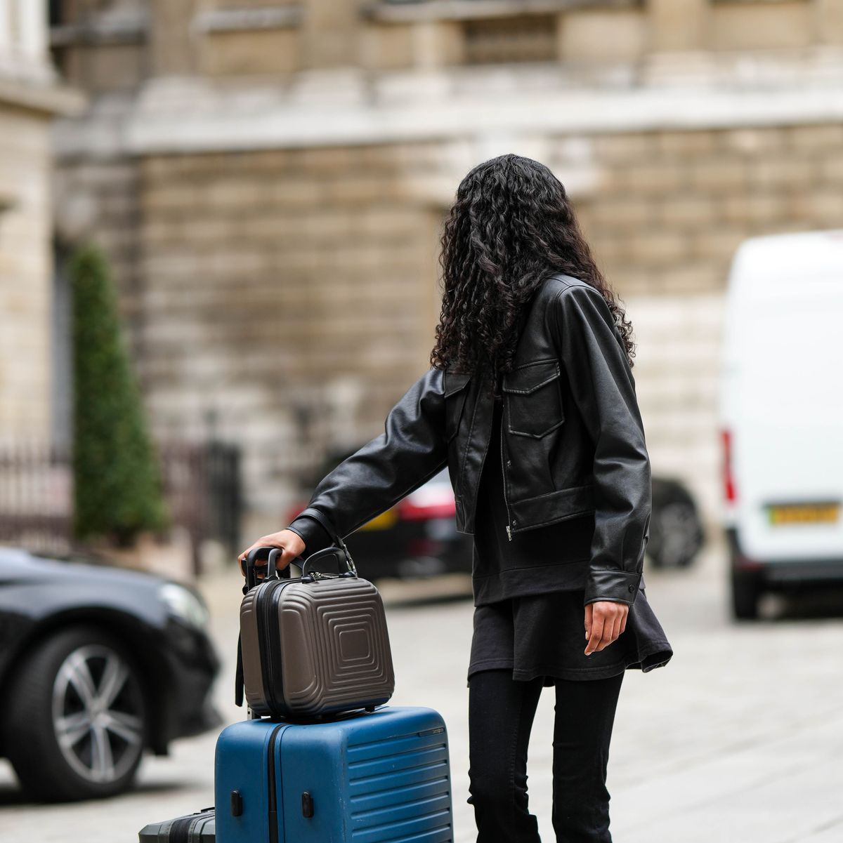 a model with a luggage set at street style lfw february 2023