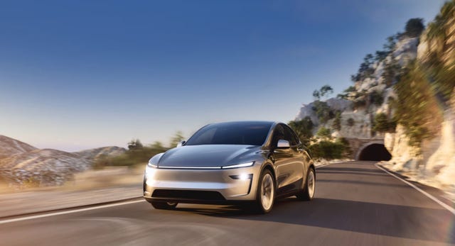 electric vehicle driving along a scenic mountain road